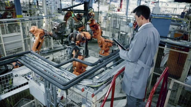 LD男亚洲工程师，在工厂检查机器人的工作流程视频素材