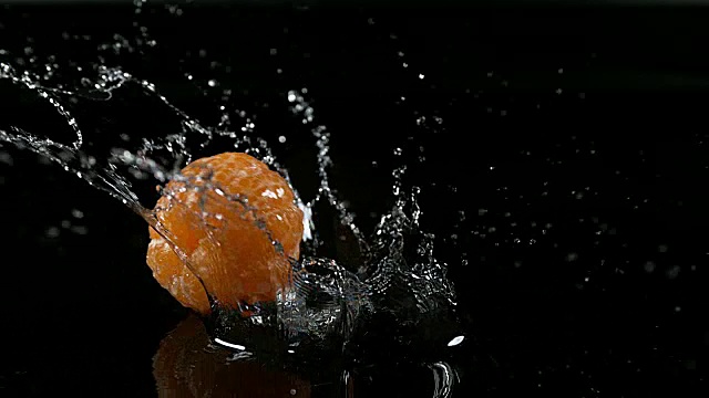 小柑橘，网纹柑橘，水果落在水对黑色背景，慢镜头4K视频素材