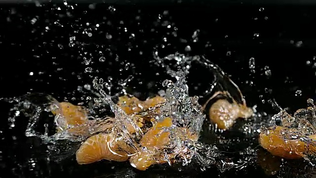 小柑橘，网纹柑橘，水果落在水对黑色背景，慢镜头4K视频素材