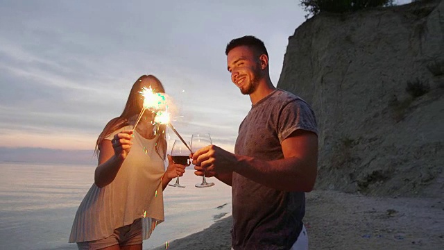 年轻情侣用烟花和葡萄酒庆祝视频素材