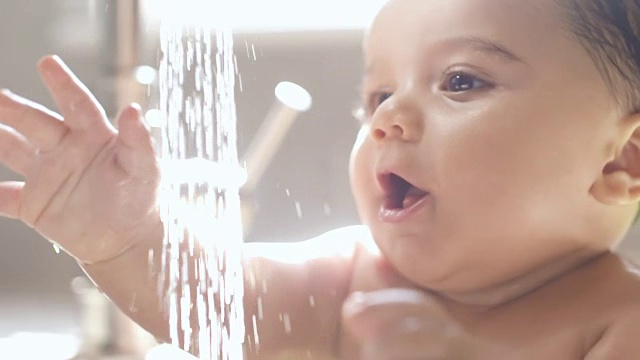 婴儿在水槽洗澡和玩水，笑视频素材