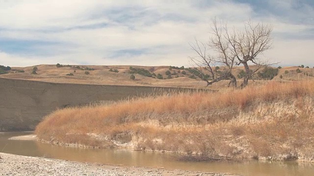 浑浊慵懒的河水流经干涸的草原草原景观视频素材