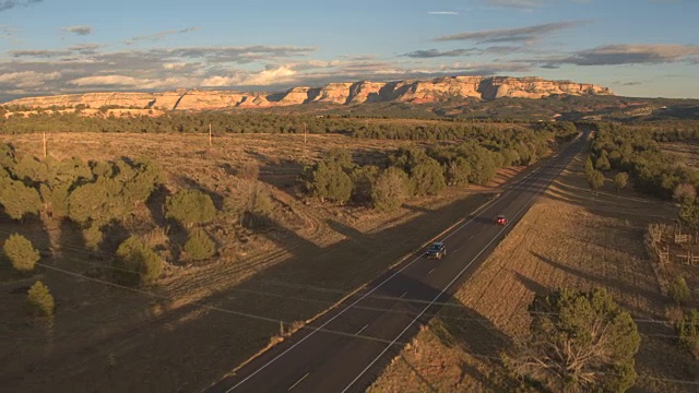 图片:黑色SUV吉普车行驶在空旷的道路上，穿过阳光明媚的犹他州风景视频下载