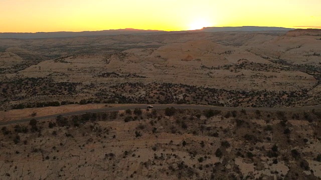 图片:黑色SUV在夕阳下沿着山脊公路行驶视频素材
