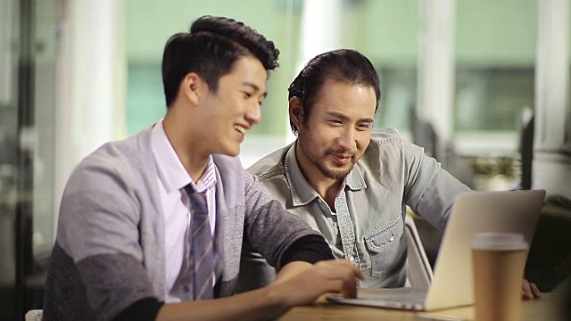 两个亚洲公司的人在办公室里讨论生意视频素材