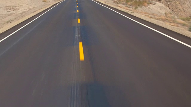 空中飞行在空旷的公路上穿过广阔的沙漠，秋天的犹他州，美国视频下载