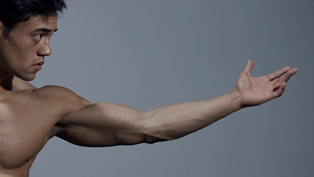 男性健身模型伸展他的手臂和弯曲他的二头肌视频下载