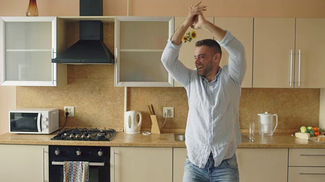 英俊的年轻有趣的男人在厨房跳舞在家里的早上和有乐趣的假期视频素材