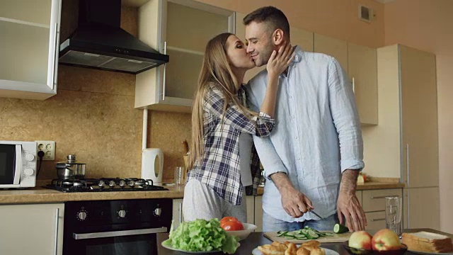 一对幸福的年轻夫妇一大早就在厨房一起做早餐视频素材