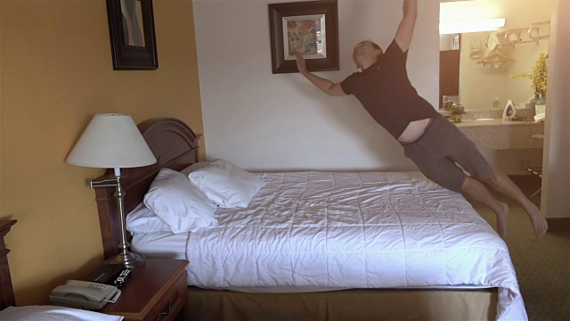 一个男人在床上跳的慢镜头视频素材