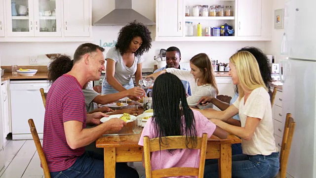 两个有十几岁孩子的家庭在厨房吃饭视频素材
