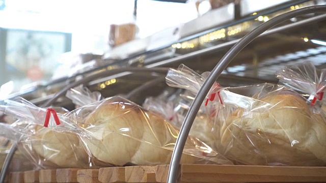 特写女人在超市里选择一条新鲜的面包。视频下载