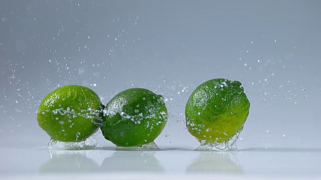 绿柠檬，橙叶，水果落在水上，慢镜头4K视频素材