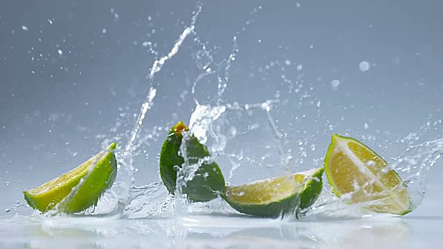 绿柠檬，橙叶，水果落在水上，慢镜头4K视频素材