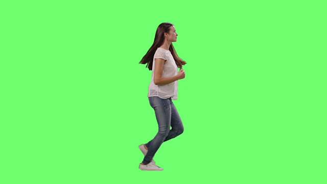 适合年轻女孩穿着休闲衣服跑在模拟绿色屏幕。视频素材