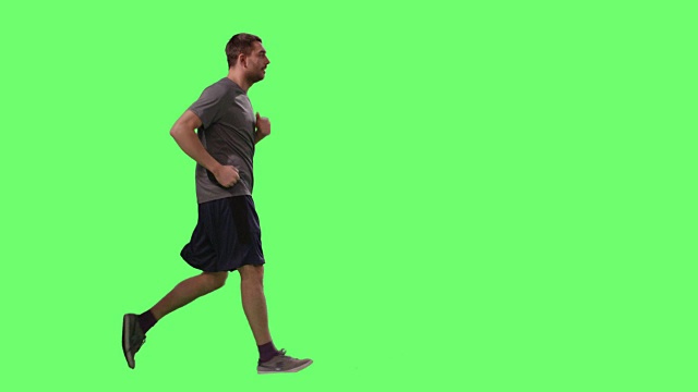 一名男子在t恤运动行走在模型的绿色屏幕在背景。视频下载