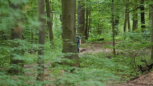 在森林里骑自行车的人越来越近了视频素材
