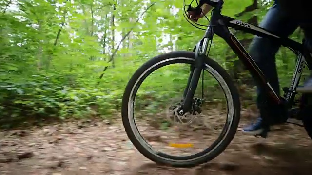 在森林道路上骑自行车的人的稳定凸轮视图视频素材