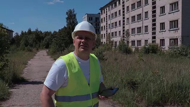 建筑工人在废弃的公寓附近拍照视频素材