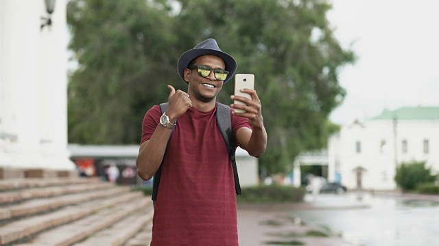 非裔美国学生在户外用他的智能手机摄像头进行在线视频聊天视频素材