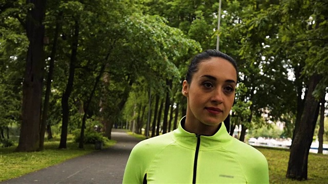 年轻的女跑步者在公园里微笑着跑得很快视频素材