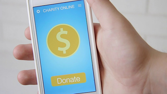 一名男子通过智能手机上的慈善应用进行在线捐赠视频素材