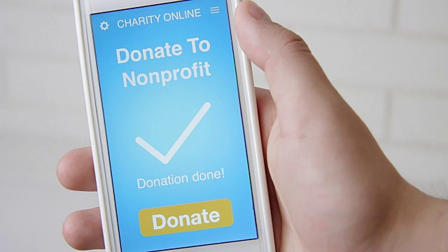 一名男子通过智能手机上的慈善应用程序向非营利组织在线捐款视频素材
