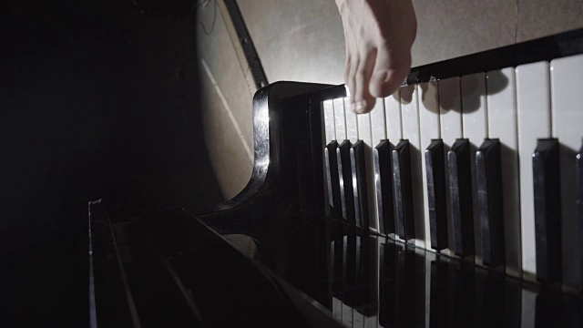 男人的脚在一架漂亮的大钢琴上弹奏着一首温柔的曲子。视频素材