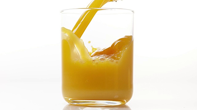 在白色背景下，将橙汁倒入玻璃中，慢动作4K视频下载