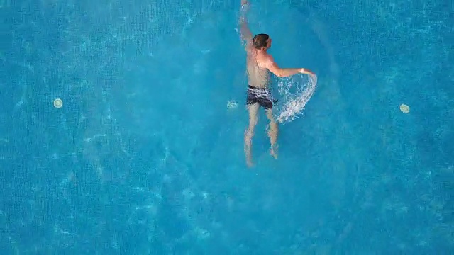 空中FullHD。有人在酒店的游泳池里游泳。从以上观点。视频下载