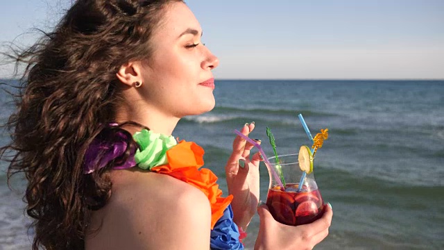 性感的女孩在海滩上的肖像，暑假，女人看大海海洋和喝鸡尾酒视频素材