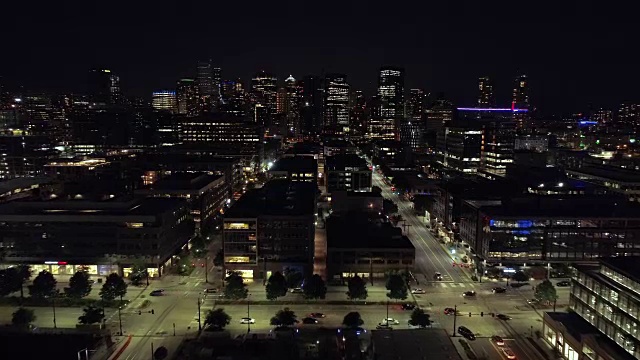 美国主要城市夜间的漂浮空中，人们在灯火通明的街道上开车视频素材
