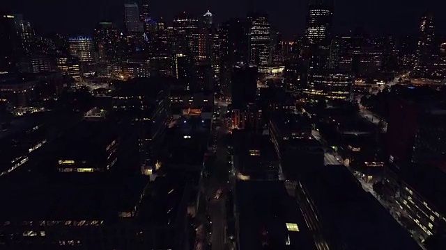 直升机在夜间展示城市的摩天大楼视频素材