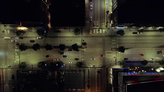夜间通过十字路口的汽车通过城市街区的架空天线视频下载