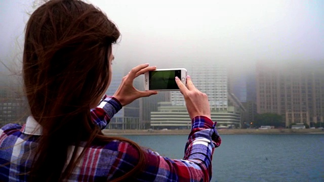 手持手机拍摄城市雾。移动摄影的概念视频素材