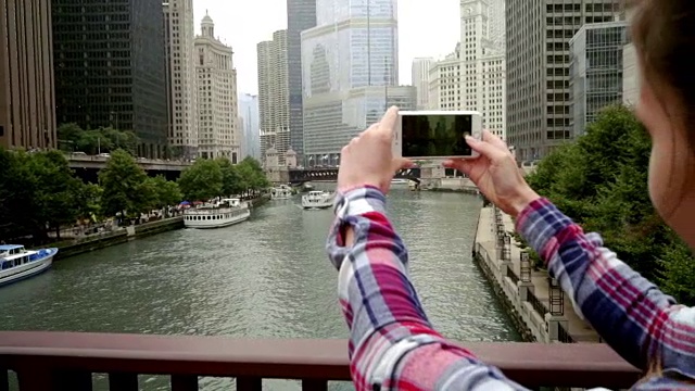 女人拍摄商业城市景观。女性摄影城市摩天大楼视频素材