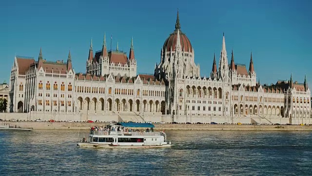 一艘游船在多瑙河上航行，背景是布达佩斯的匈牙利议会大楼视频下载