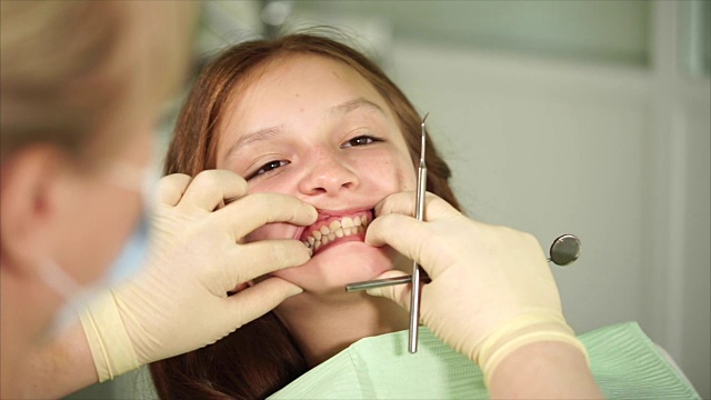 Orthodon正在检查一个来诊所接受治疗的青少年的牙齿视频下载