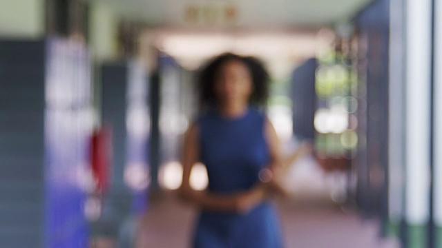 黑人女教师走进学校走廊的焦点视频素材