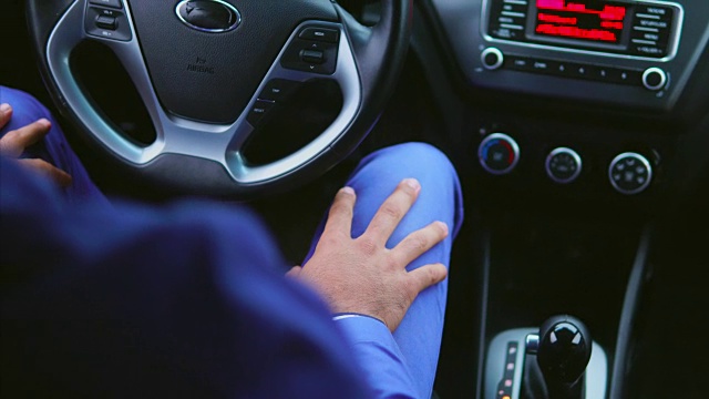 一个穿蓝色西装的阿拉伯人坐在车里的驾驶座上。视频下载