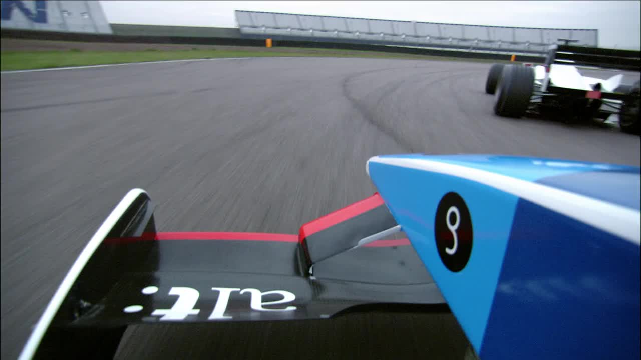 低角度中景拍摄的角度超过翼一级方程式赛车追逐赛车在赛道上视频素材