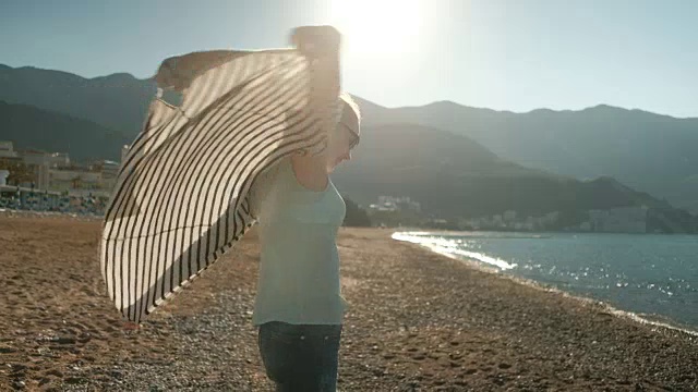 女人走在海边，遥望远方，风吹t恤视频素材