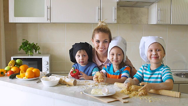 幸福家庭在厨房的肖像。孩子们和妈妈一起学习做饭视频素材