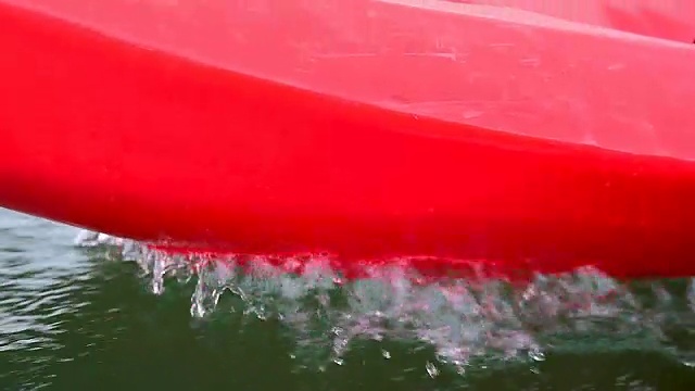 红色的独木舟溅起水花。视频下载