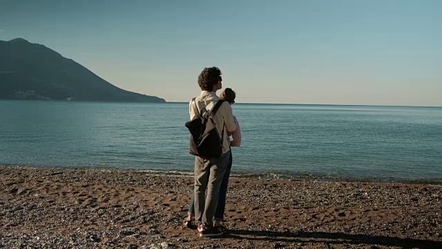 爱的幸福的夫妇走在湖上，站在后面，在户外拥抱视频素材