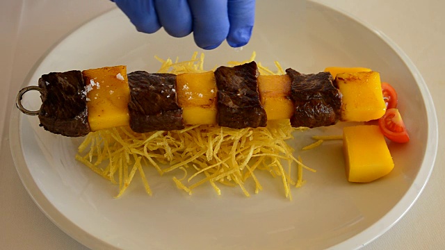 专业厨师将红肉和芒果串放在盘子上视频素材
