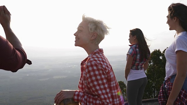 男人用手机拍摄日出景观，山顶上的人后视镜，旅游团视频素材