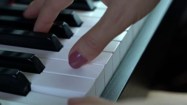 一个女人在弹钢琴的特写视频素材