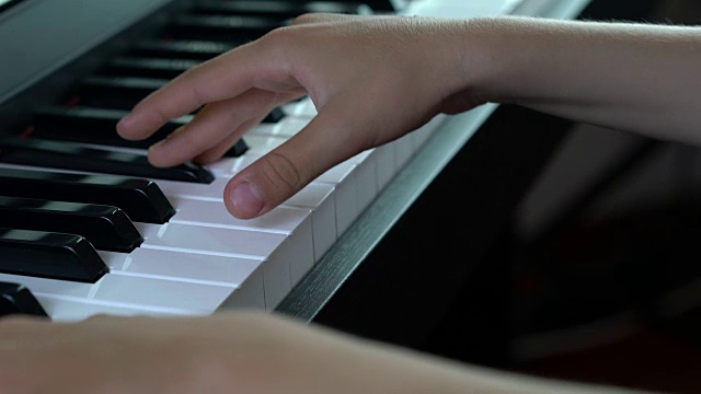 一个孩子在弹钢琴的特写视频素材