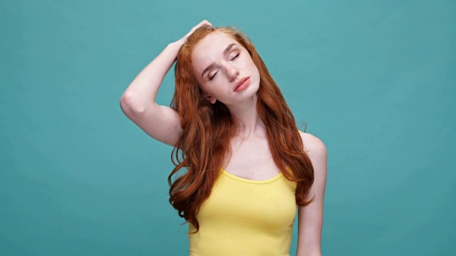 很累的红发女孩是无聊的孤立在蓝色的背景视频素材